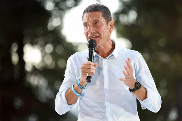 David Lisnard en chemise blanche parlant dans un microphone et gesticulant lors d'une prise de parole en extérieur, lors de sa campagne présidentielle en Alsace