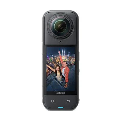 Caméra d'action 360° Insta360 X5 en gros plan avec grande lentille en haut et écran tactile montrant un selfie grand-angle de deux personnes devant une skyline urbaine nocturne