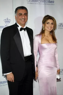 Yasmine Pahlavi en robe de soirée rose pâle et Reza Pahlavi en smoking noir posant côte à côte sur le tapis rouge des Princess Grace Awards, devant un mur de fond événementiel
