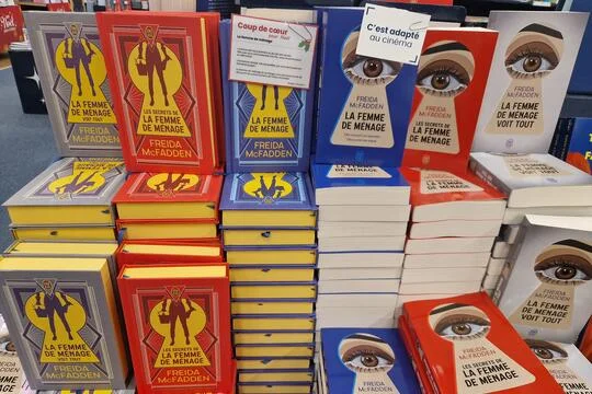 Présentoir de librairie garni de piles de romans de Freida McFadden publiés aux éditions J'ai Lu, dont « La Femme de Ménage » et « La Femme de Ménage Voit Tout »