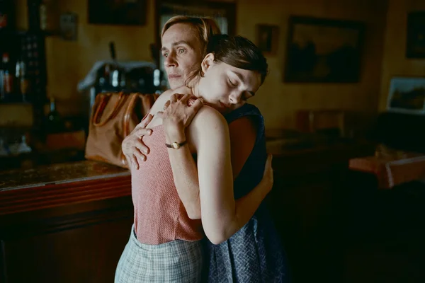 Scène du film « L'Événement » : deux femmes se réconfortent dans un bar sombre, l'une aux cheveux blonds courts regarde au loin, l'autre brune pose sa tête sur son épaule, les yeux fermés.