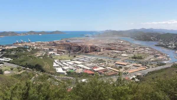 Vue aérienne de l'usine SLN d'Eramet à Doniambo en Nouvelle-Calédonie, située sur une plaine côtière à côté d'un fleuve et de l'océan, illustrant les déboires du minier français.