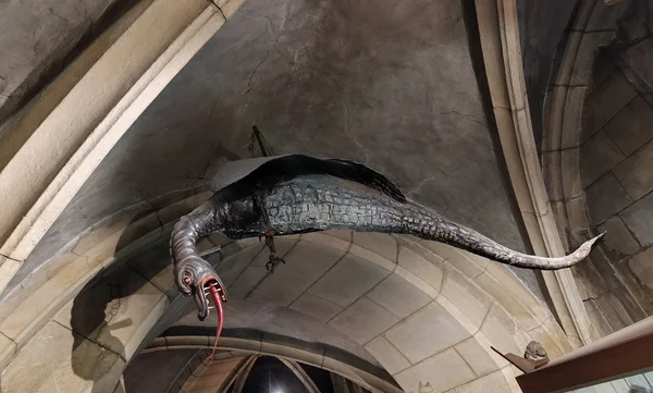 Représentation du Graoully, dragon légendaire de la cathédrale Saint-Étienne de Metz, suspendue sous une voûte en pierre ornée, gueule ouverte et langue tirée.