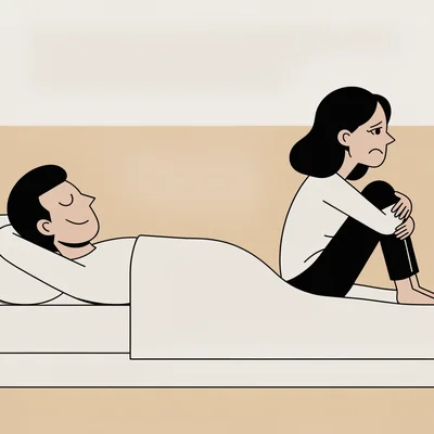 Vue de côté d'un couple hétérosexuel allongé sous un drap dans une chambre minimaliste : l'homme, détendu et satisfait, est séparé de la femme, assise à demi, les genoux ramenés contre elle et le regard pensif, par un large espace vide sur le matelas.