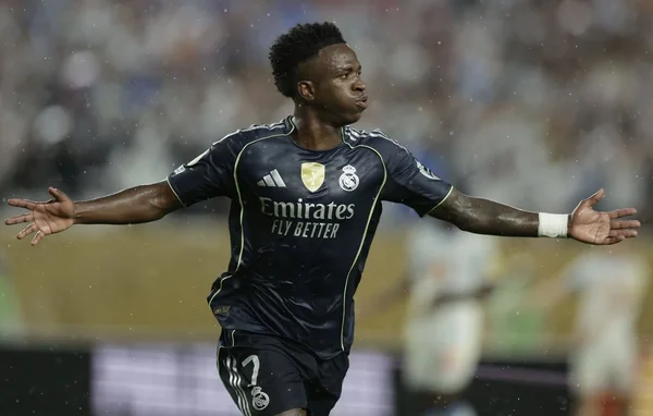Vinícius Júnior, en maillot bleu marine du Real Madrid, bras écartés sur une pelouse détrempée, célèbre lors du match de Coupe du monde des clubs 2025 contre la Juventus.