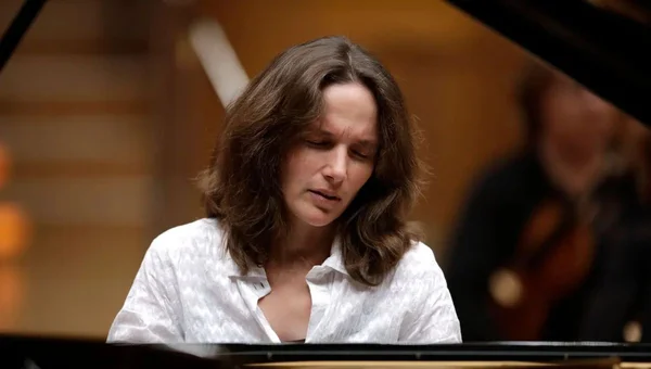 Hélène Grimaud, cheveux bruns ondulés et chemise blanche à col, joue du piano à queue avec concentration, dans le Concerto pour piano n°4 de Beethoven diffusé par France Musique.