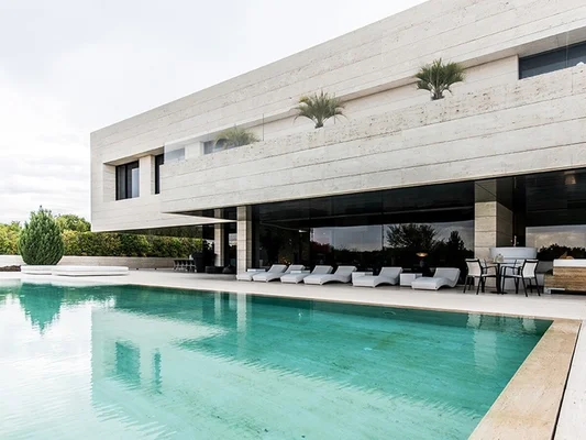 Maison de luxe minimaliste avec piscine, dans l'urbanisation La Finca à Madrid, illustrant le style d'immeuble où vivent les stars comme Zinédine Zidane.