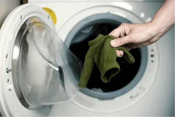 Illustration d'un pull en laine rétréci au lavage, évoquant le feutrage des fibres sous l'effet de l'eau chaude