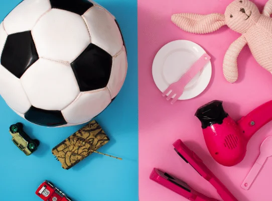 Image divisée montrant à gauche des objets stéréotypés pour les garçons (ballon de football, voitures en plastique, portefeuille) sur fond bleu, et à droite des objets stéréotypés pour les filles (lapin en peluche, sèche-cheveux rose, lisseur, couverts) sur fond rose, illustrant les stéréotypes