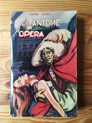 Couverture illustrée d'une édition populaire du « Fantôme de l'Opéra » de Gaston Leroux, montrant un homme masqué en cape rouge soutenant une femme évanouie.