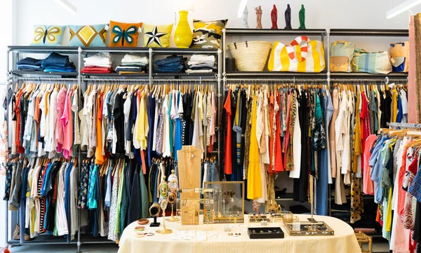 Intérieur d'une friperie lumineuse avec des étagères de vêtements colorés