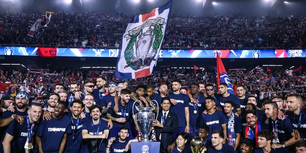 Les joueurs et le staff du PSG posant avec l'ensemble des trophées remportés sur la pelouse du Parc des Princes, devant les supporters, lors de la première à domicile de la saison.