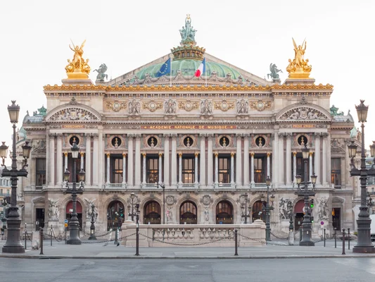 Façade du Palais Garnier à Paris, ornée de statues dorées et de colonnes, avec l'inscription « ACADEMIE NATIONALE DE MUSIQUE ».