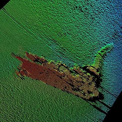 Image de sonar montrant un épave d'un bateau sur le fond du loch, rendu en tons verts et bleus avec l'épave en brun rougeâtre, illustrant les détections sonar du Loch Ness depuis 1970